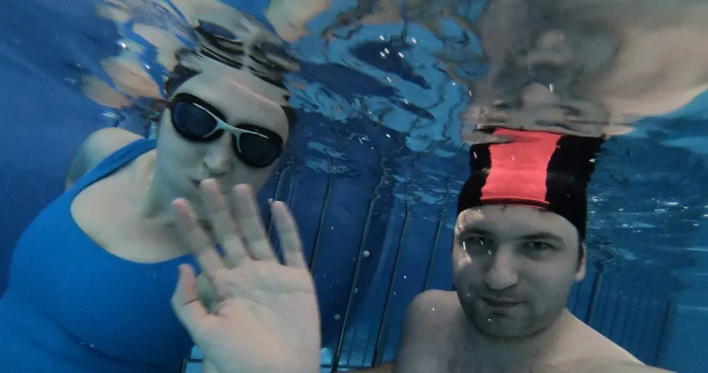 osoba dorosła zanurzająca twarz w wodzie basen