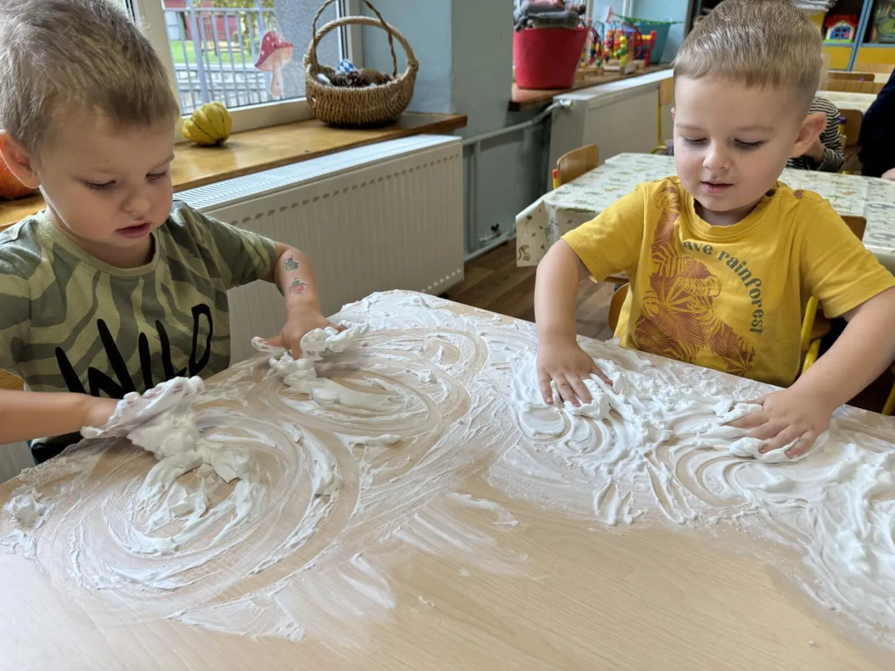 dziecko bawiące się pianką do golenia na stole