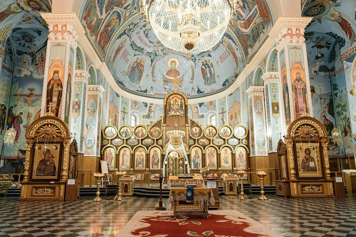 Wnętrze cerkwi z ikonostasem i freskami. Różnica między bazyliką a katedrą i sanktuarium znaczenie rangi jest widoczne w architekturze i wystroju.