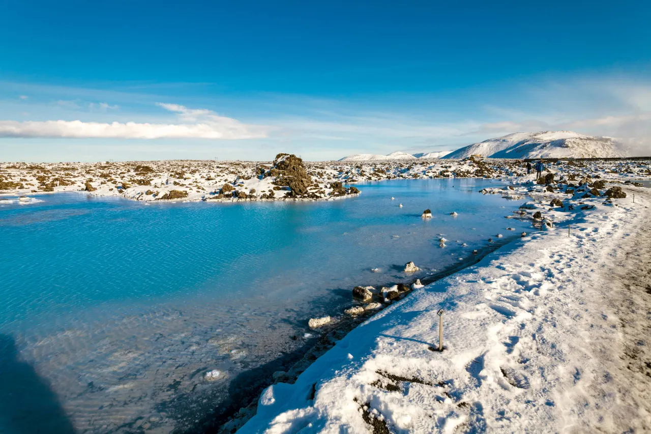 Błękitna Laguna, geotermalny basen w zimowej scenerii Islandii, otoczony śniegiem i wulkanicznymi skałami.
