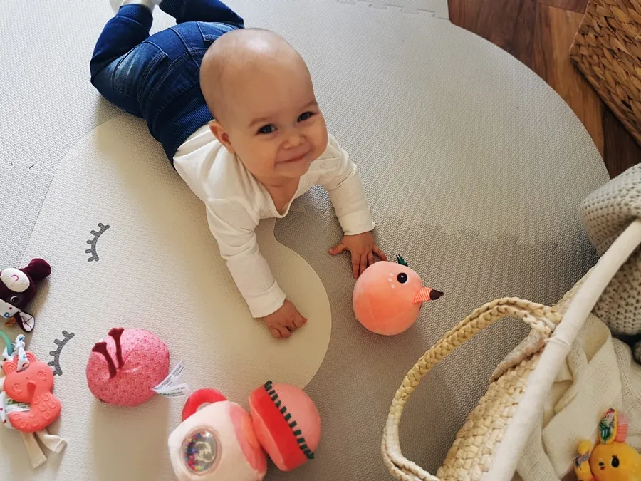 niemowlę z zaciekawieniem sięga po zabawkę sensoryczną