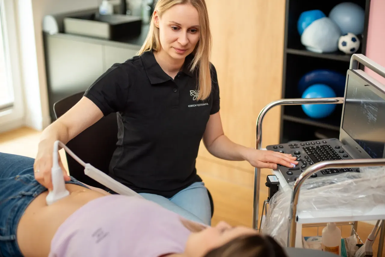 Fizjoterapeutka uroginekologiczna wykonuje badanie USG brzucha pacjentki. To pokazuje, jak wygląda wizyta u fizjoterapeuty uroginekologicznego.