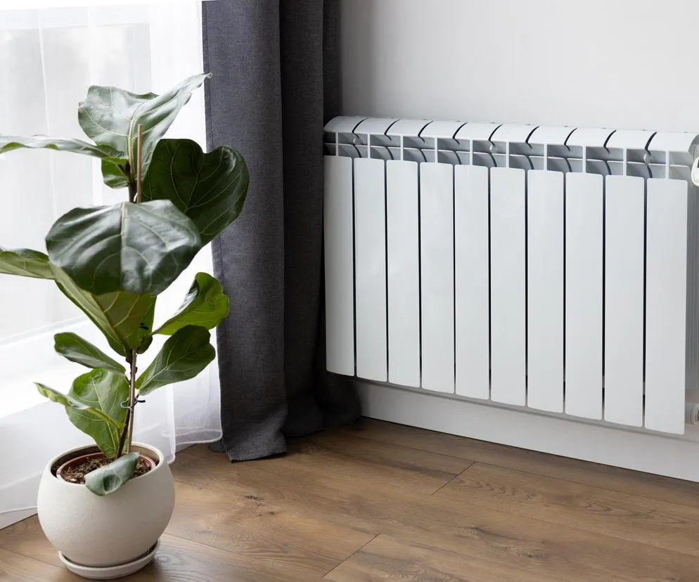 Hydraulik naprawiający grzejnik w bloku, zgłoszenie awarii sp&oacute;łdzielnia