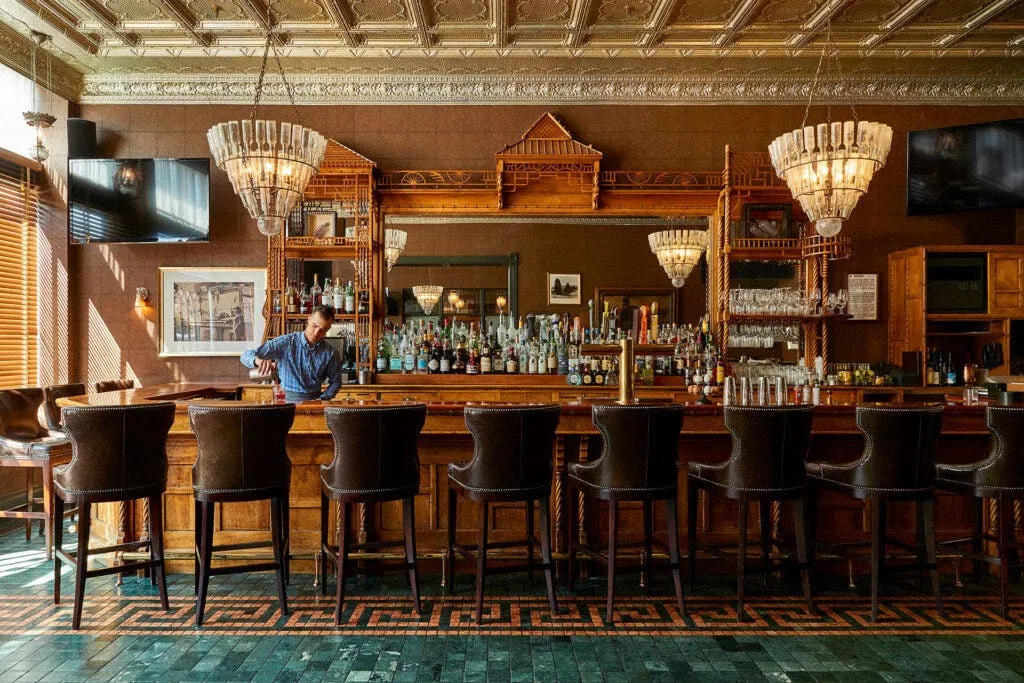 luxury hotel bar interior vs a cozy local pub interior side by side