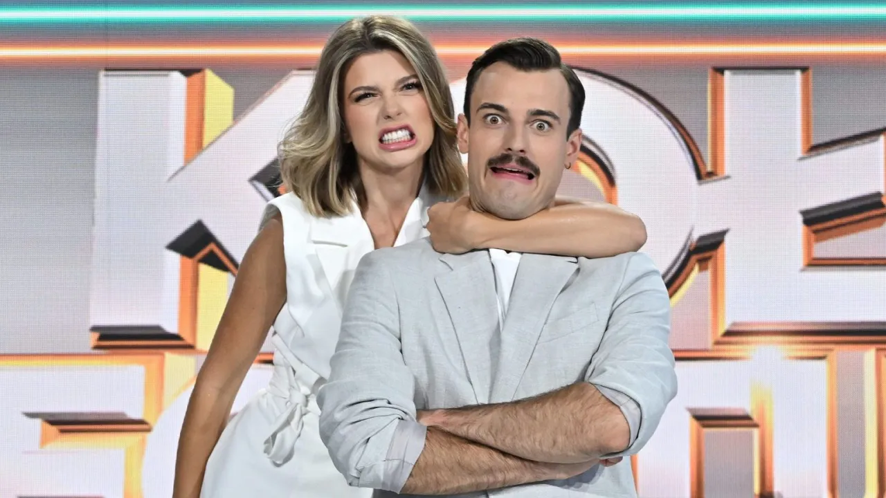 Kobieta dusi mężczyznę na tle scenografii 