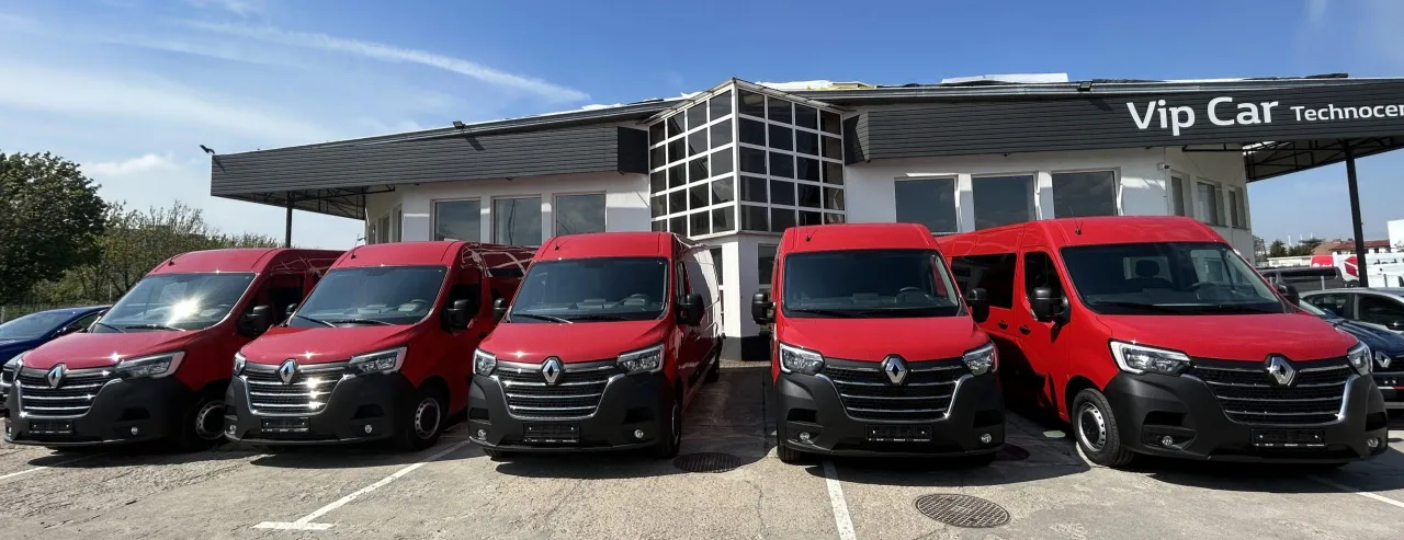 Rzędy czerwonych busów Renault przed budynkiem Vip Car Technocenter. Zastanawiasz się, ile kosztuje bus do Niemiec?