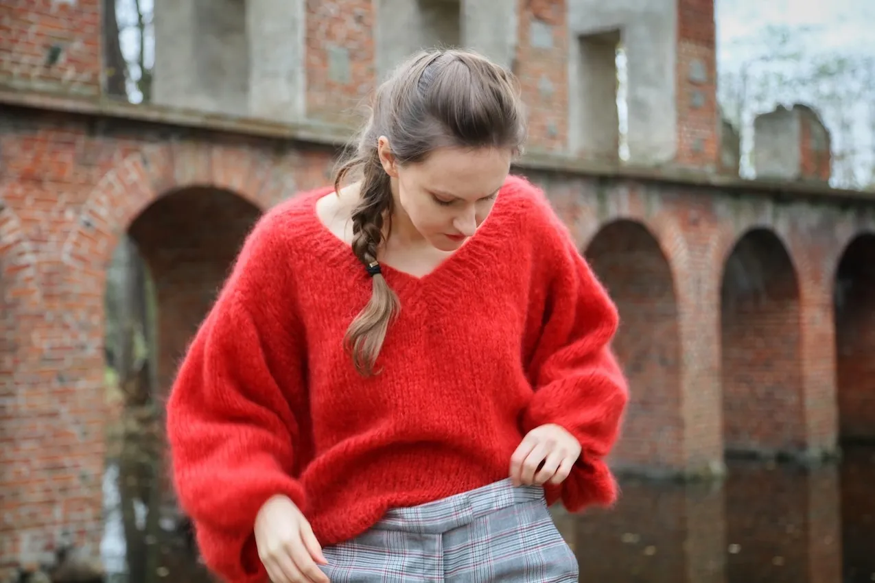 Kobieta w czerwonym swetrze z moheru, inspiracja jak zrobić sweter z moheru.