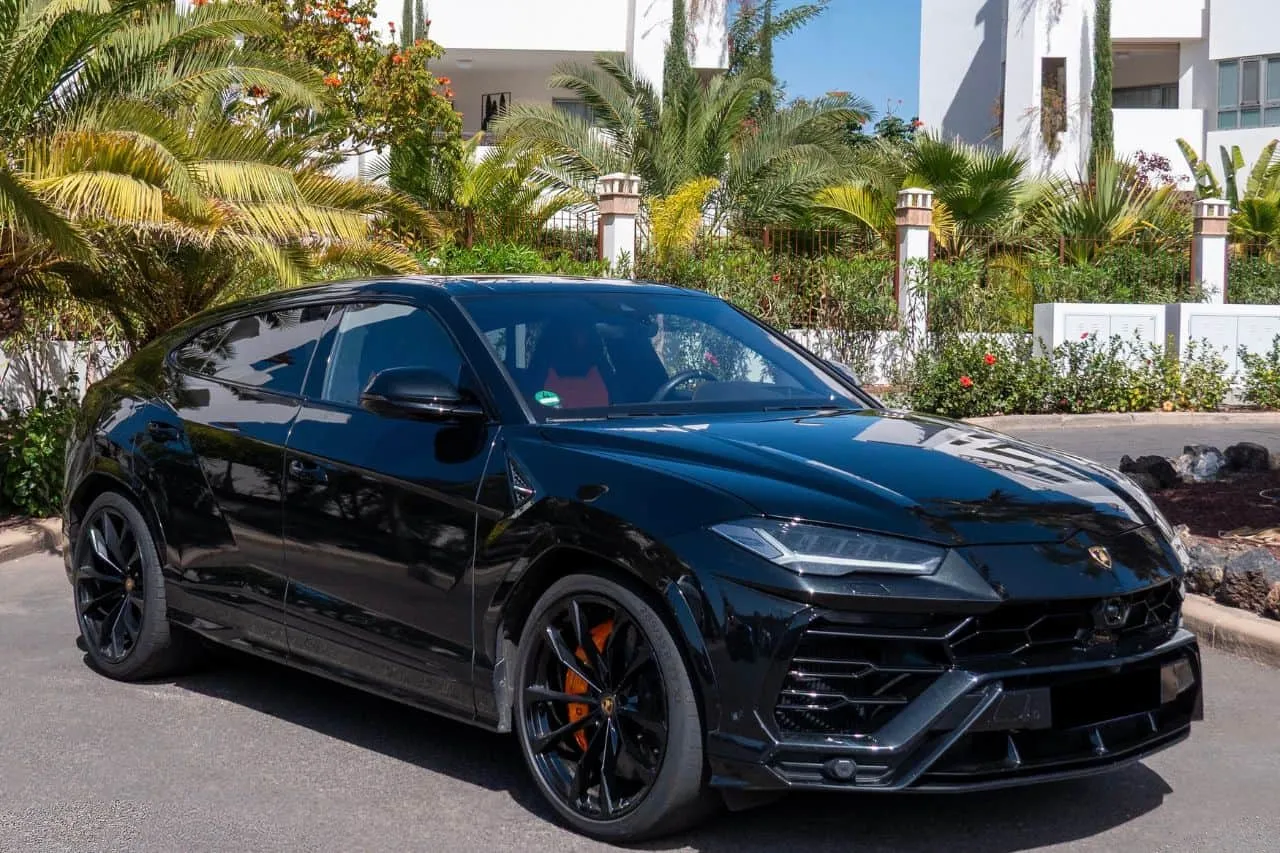Czarny Lamborghini Urus na tle luksusowej willi. Zastanawiasz się, ile kosztuje wypożyczenie lamborghini na wakacje?