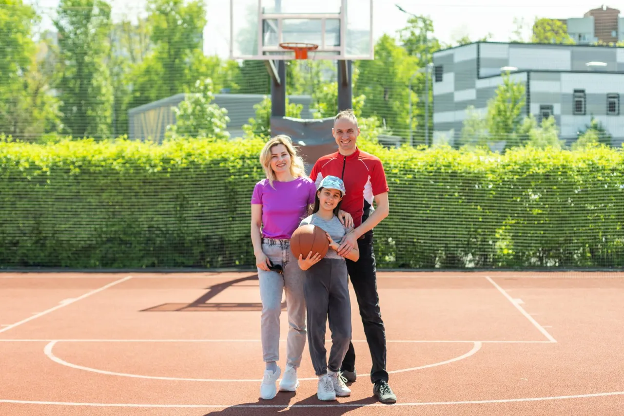trener koszykówki rozmawia z grupą dzieci na boisku