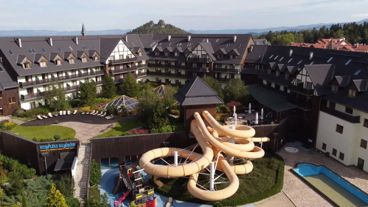 Karpacz noclegi z basenem i wyżywieniem: hotel z basenami, zjeżdżalniami i placem zabaw, otoczony zielenią i górami.