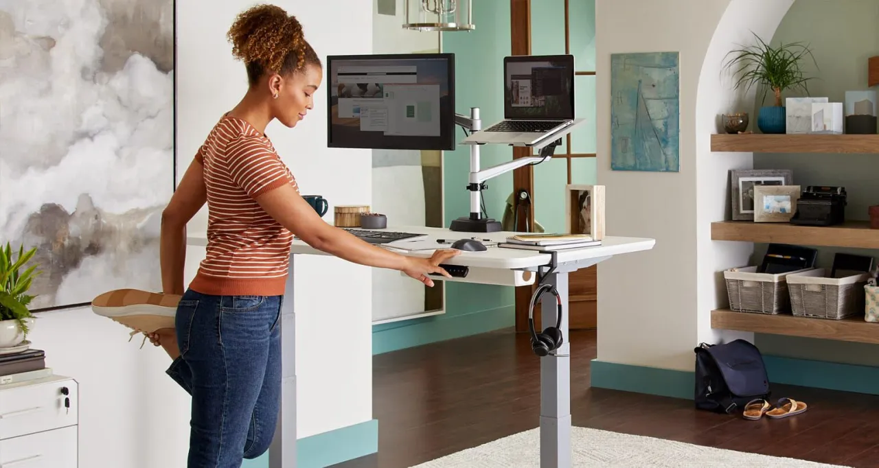 osoba siedząca przy biurku z napiętymi biodrami