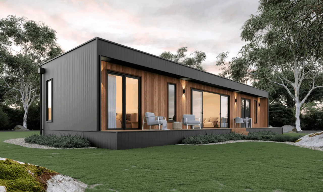 Nowoczesny dom modułowy co to? Elegancka bryła z drewnianą elewacją, dużymi przeszkleniami i tarasem, otoczona zielenią.