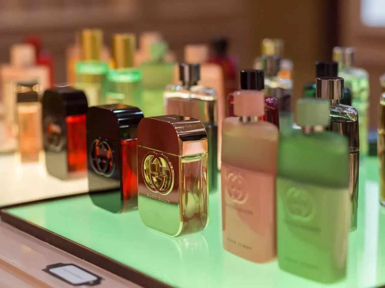 Eleganckie flakony perfum Gucci Guilty na zielonym tle. Szukasz, gdzie kupić oryginalne testery perfum? To miejsce może być odpowiedzią.