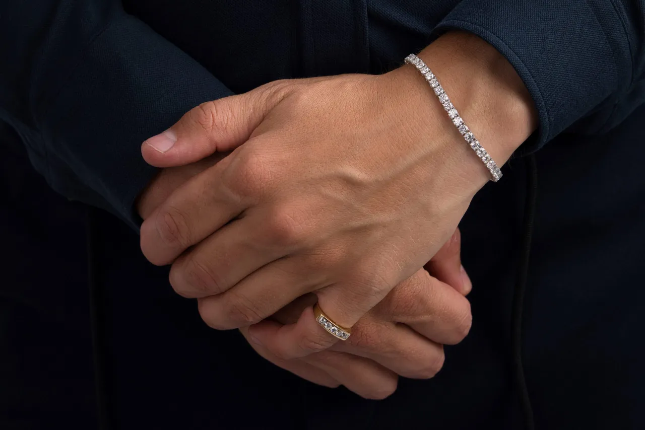 Mann trägt elegantes Tennisarmband aus Gold mit Diamanten