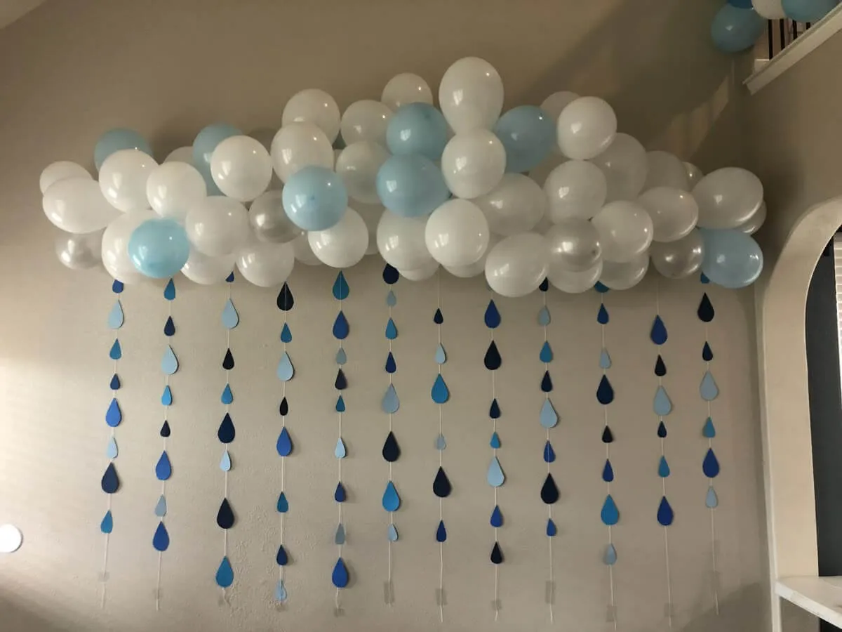Chmura z białych i błękitnych balonów, z której zwisają papierowe krople deszczu. Idealna dekoracja na baby shower zabawy!