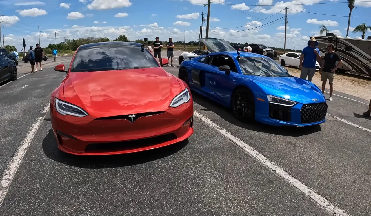 Czerwona Tesla i niebieskie Audi R8 gotowe do wyścigu na 100 km/h.