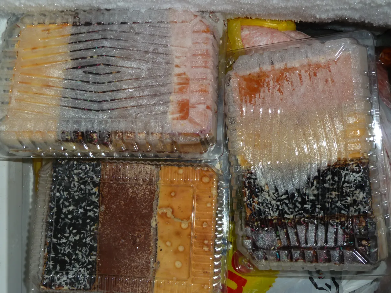 W zamrażarce widać kilka rodzaj&oacute;w ciast w plastikowych opakowaniach. To dow&oacute;d, jakie ciasta można mrozić, by cieszyć się nimi p&oacute;źniej.