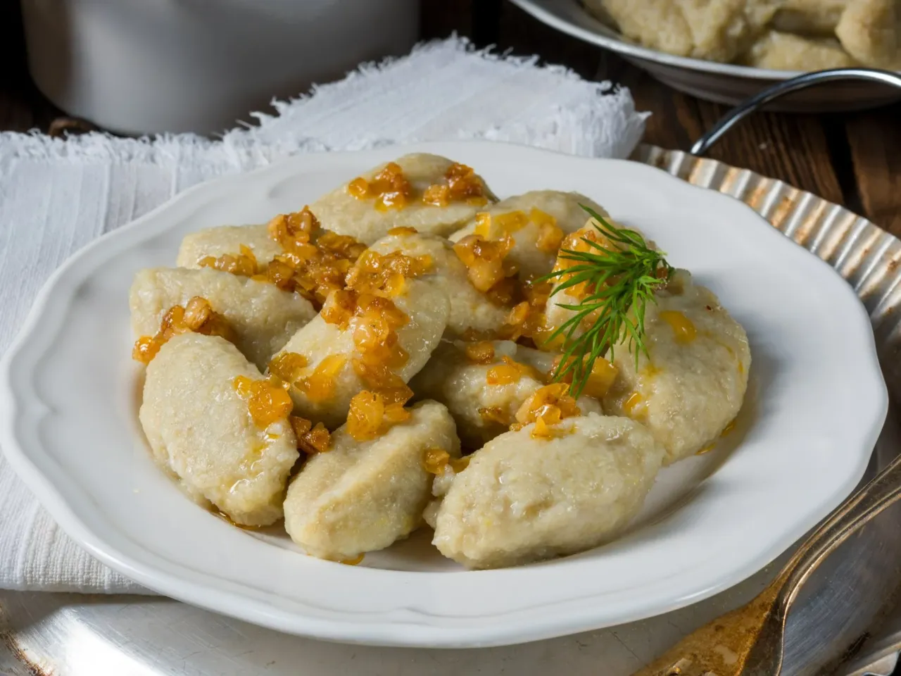 Pyszne kluski leniwe polane skwarkami. Wiesz, ile gotować kluski mrożone, by były idealne?