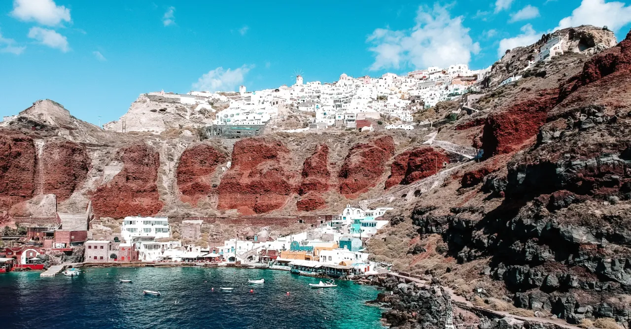 Santorini, jedno z 100 najpiękniejszych miejsc na świecie, z białymi domkami na klifie i turkusową wodą.