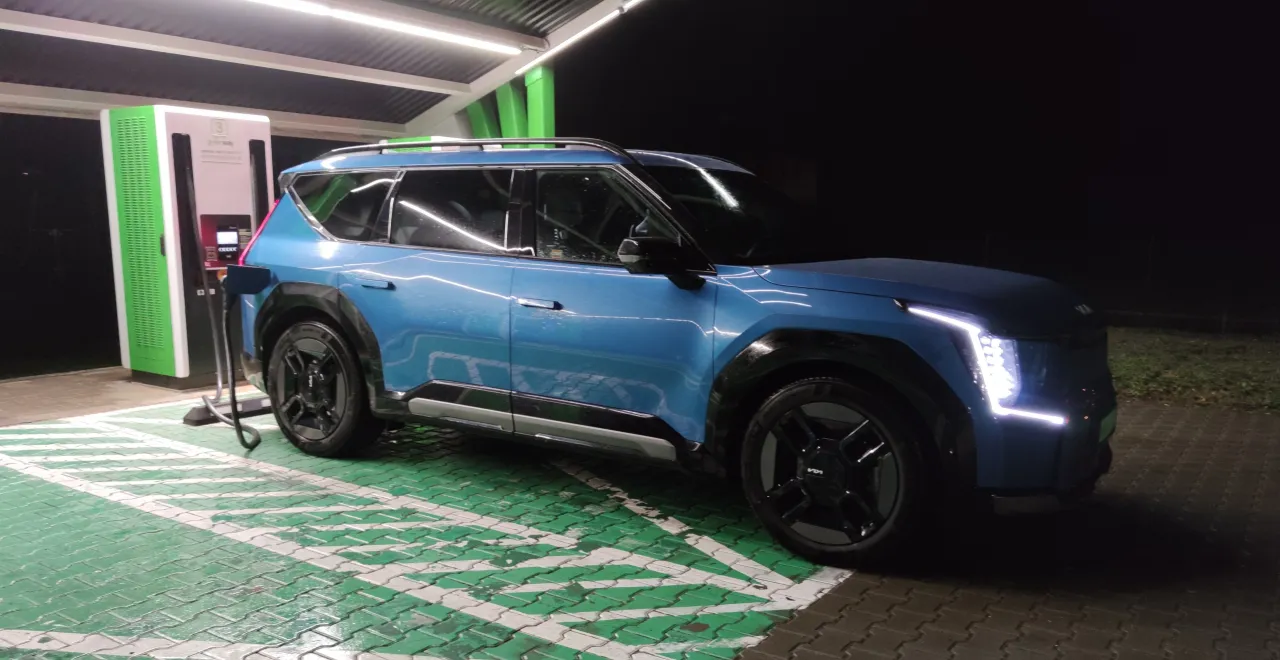 Niebieski samochód elektryczny ładuje się na stacji. Zastanawiasz się, ile kosztuje ładowanie samochodu elektrycznego?