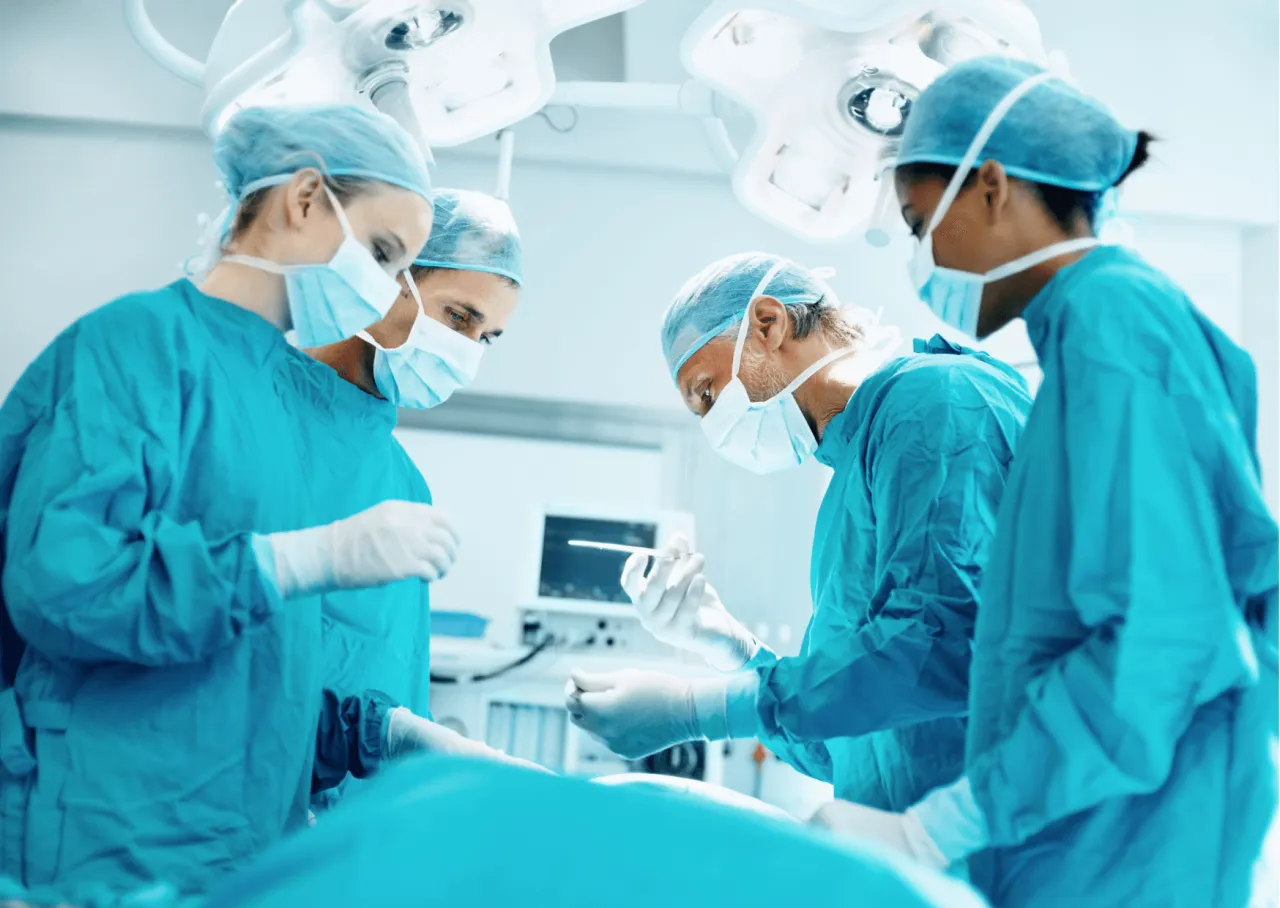 Zesp&oacute;ł chirurg&oacute;w w maseczkach i fartuchach skupiony na operacji. Czy to moment, gdy m&oacute;gł nastąpić błąd pielęgniarki?