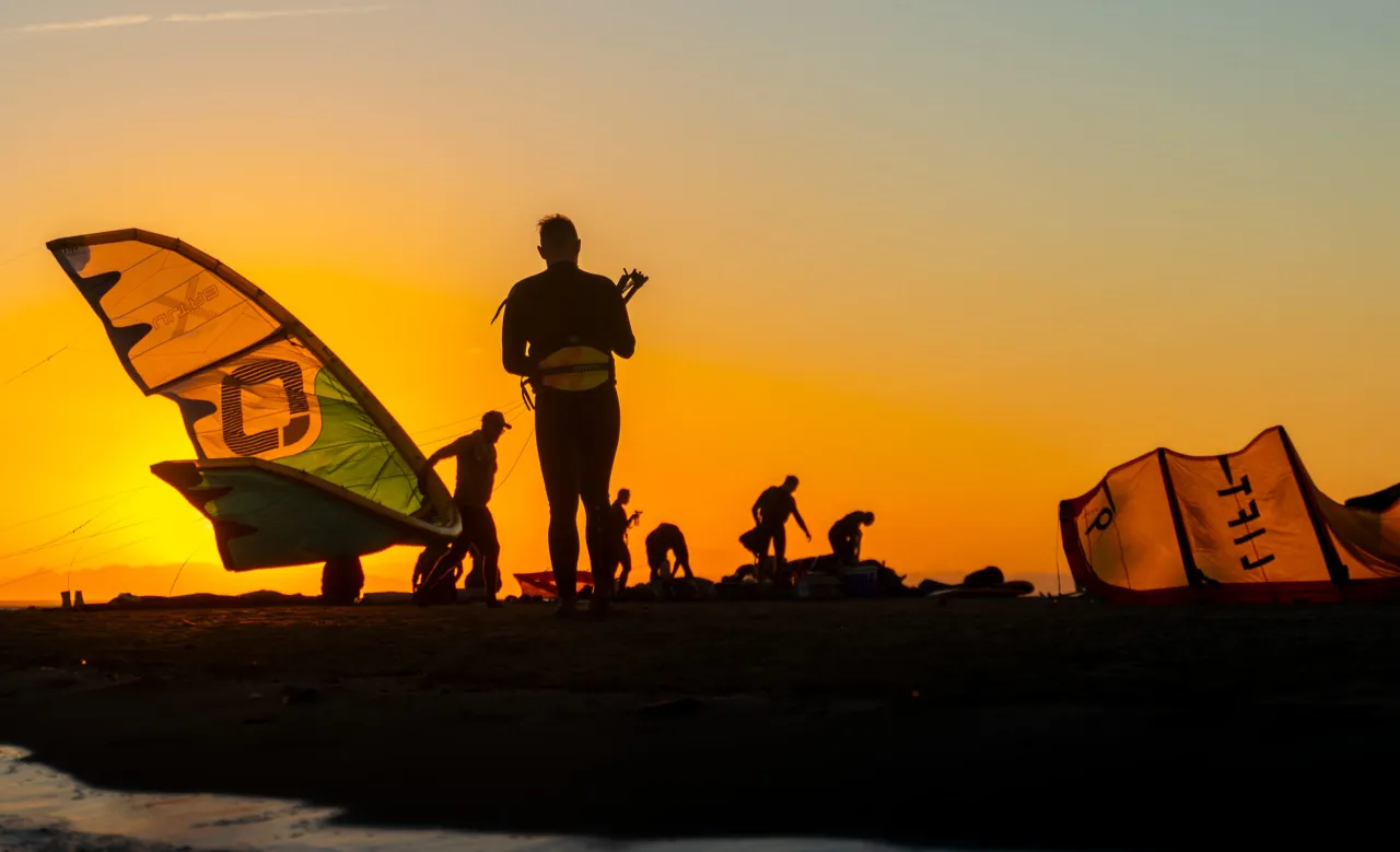 Kitesurfer w kasku i kamizelce asekuracyjnej na tle bezpiecznej plaży