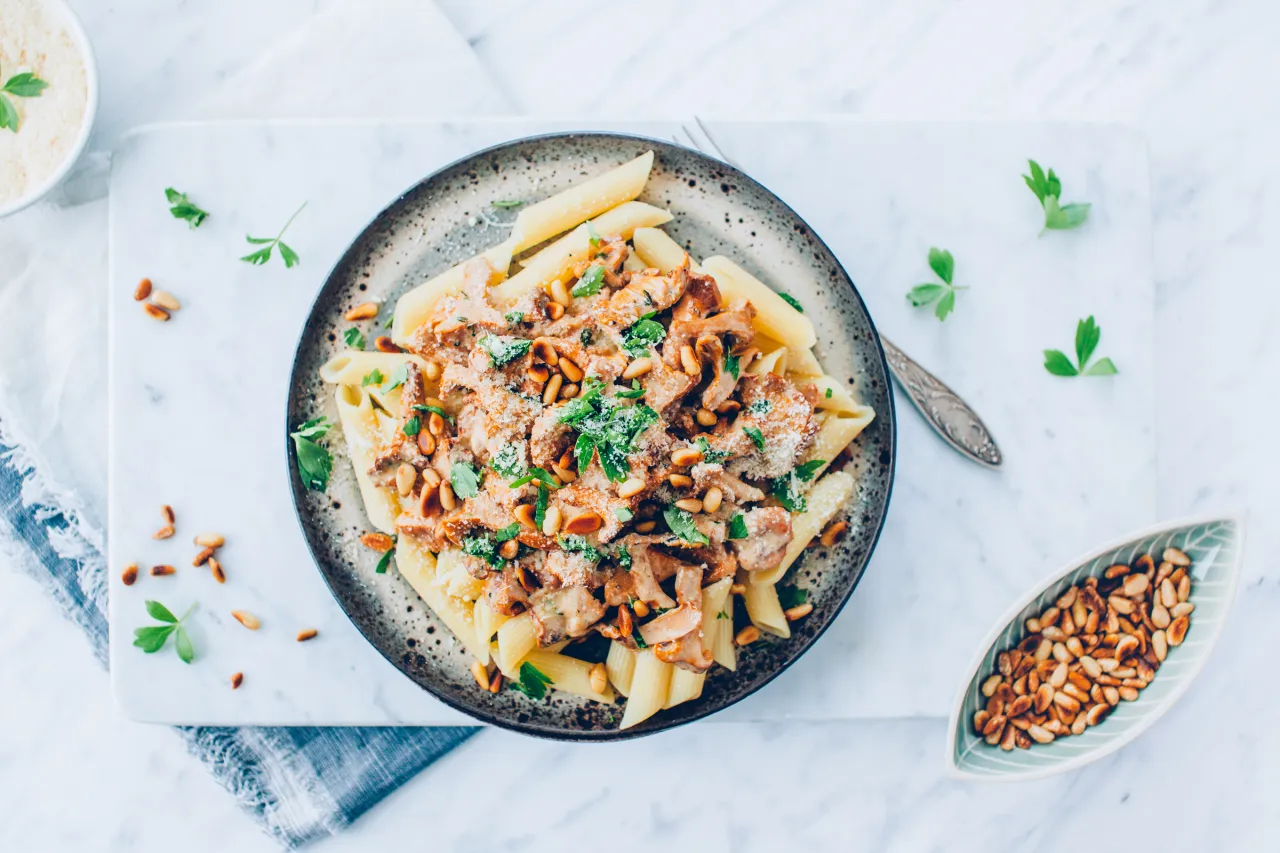 Penne z kurkami w śmietanie, posypane parmezanem i orzeszkami pinii. Idealny przepis na to, jak zrobić sos z kurek w śmietanie.