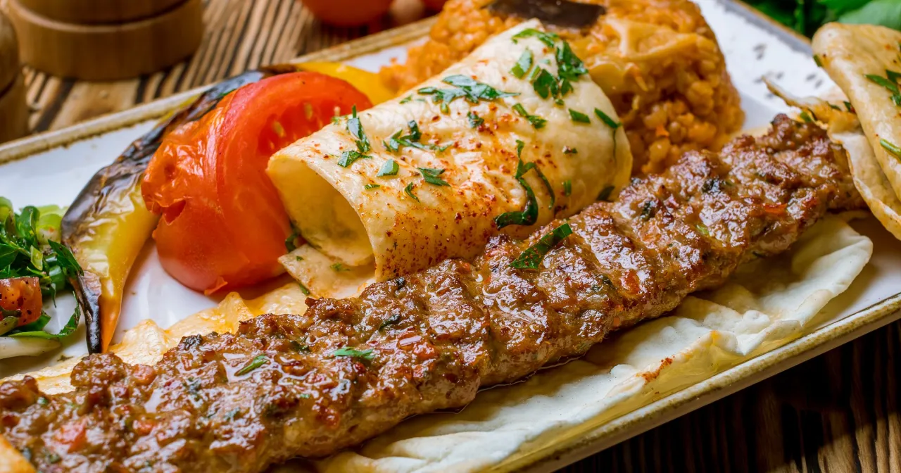 Pyszny kebab na talerzu z ryżem i warzywami. Zastanawiasz się, ile kalorii ma ten kebab?