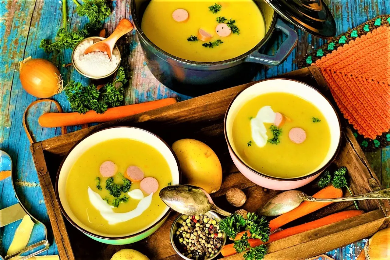 Verschiedene Toppings f&uuml;r M&ouml;hren Kartoffel Suppe wie W&uuml;rstchen Croutons Kr&auml;uter