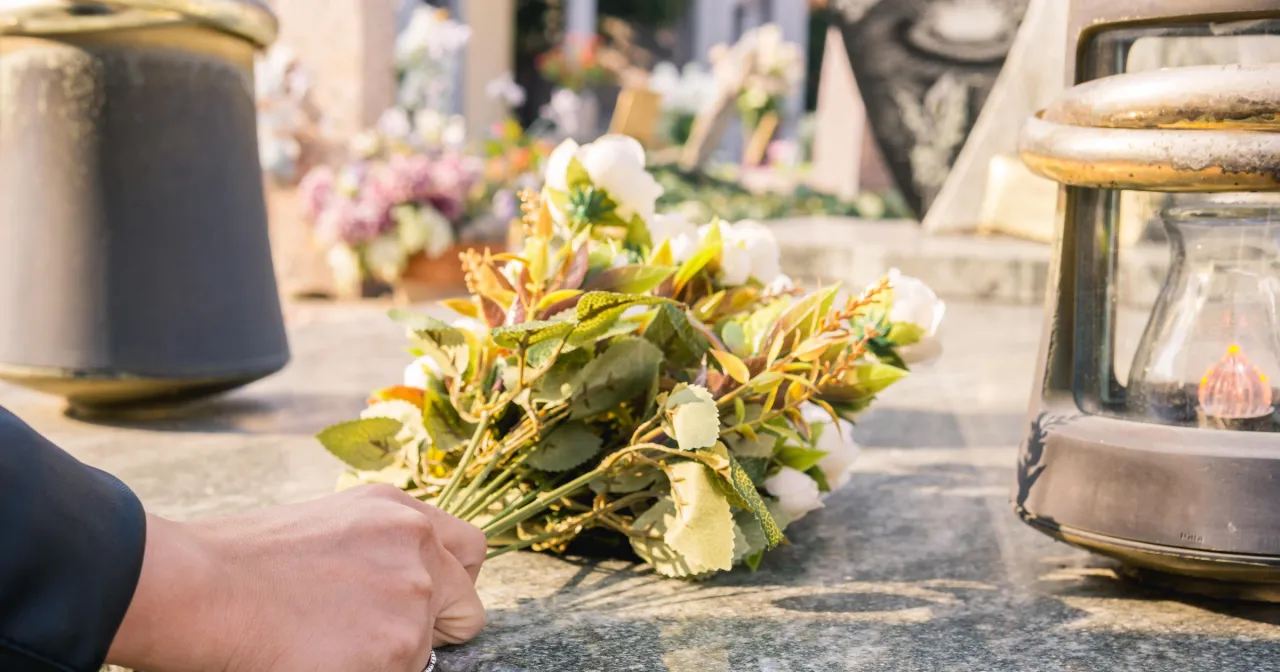 Świeżo usypany grób z kwiatami po pogrzebie