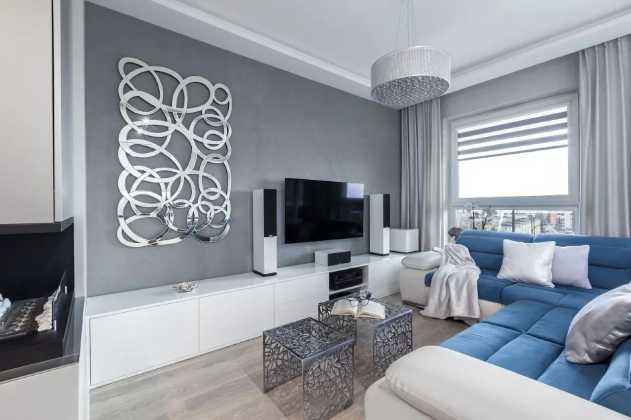 Nowoczesny salon z szarymi meblami i kolorowymi dodatkami