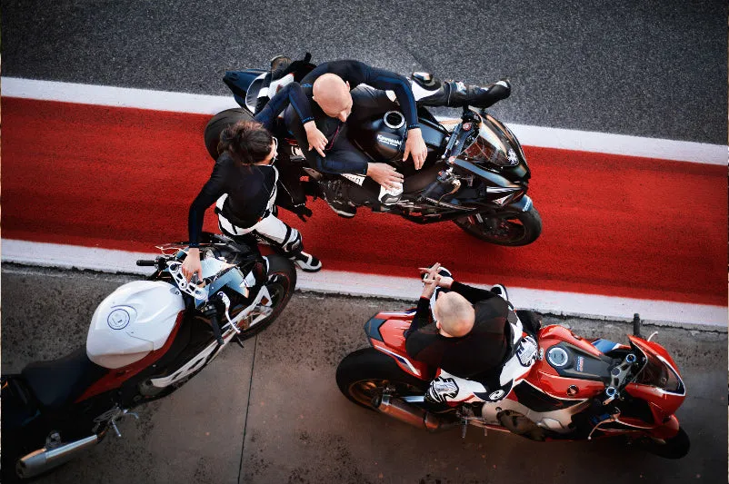 motocyklista na torze w kombinezonie jednoczęściowym i motocyklista turystyczny w dwuczęściowym