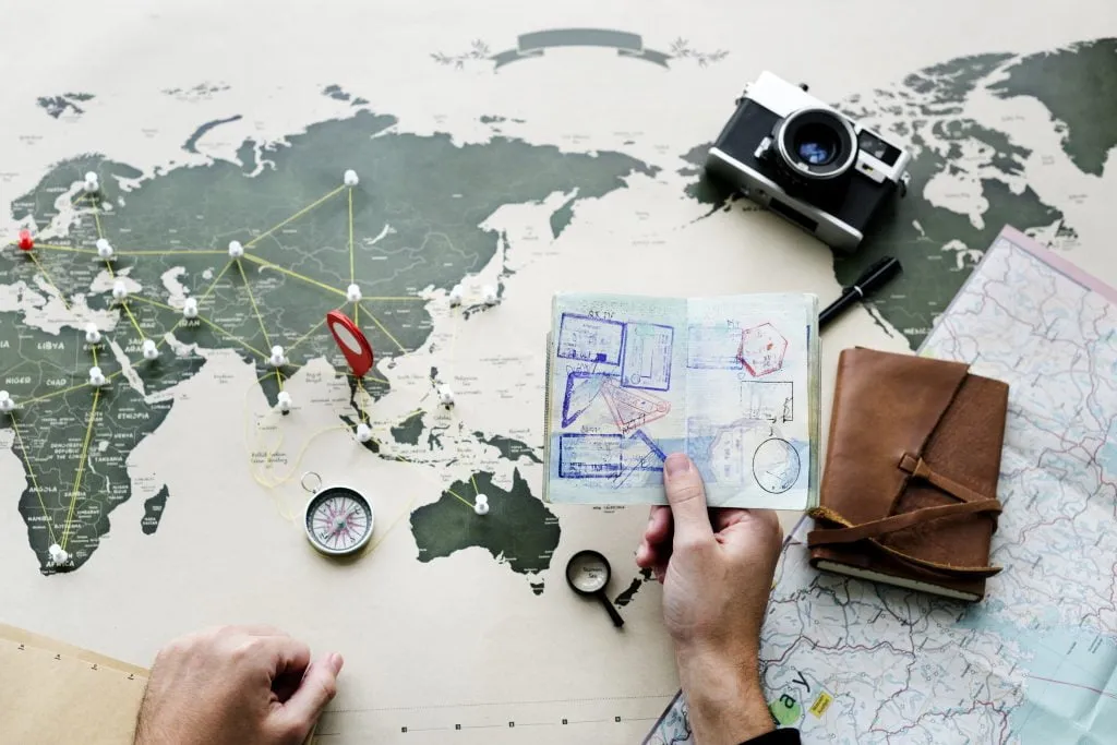 osoba planująca podr&oacute;ż lub emigrację z mapą i notatkami