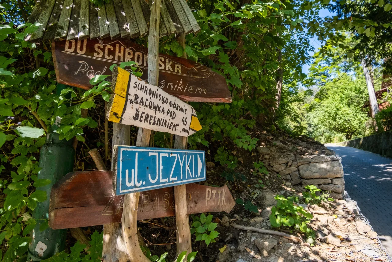 Drewniane drogowskazy wskazują drogę do schroniska g&oacute;rskiego bac&oacute;wka pod Bereśnikiem.