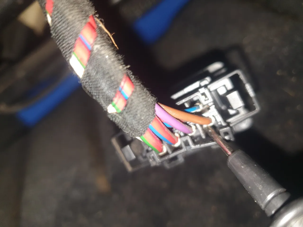 Próba naprawy wiązki przewodów w Passacie B6, gdzie nie działa podgrzewanie foteli. Widoczne kolorowe kable i wtyczka.