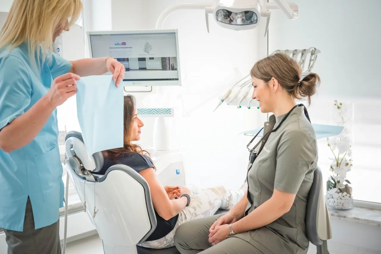 Nowoczesny gabinet stomatologiczny z uśmiechniętym dentystą i pacjentem