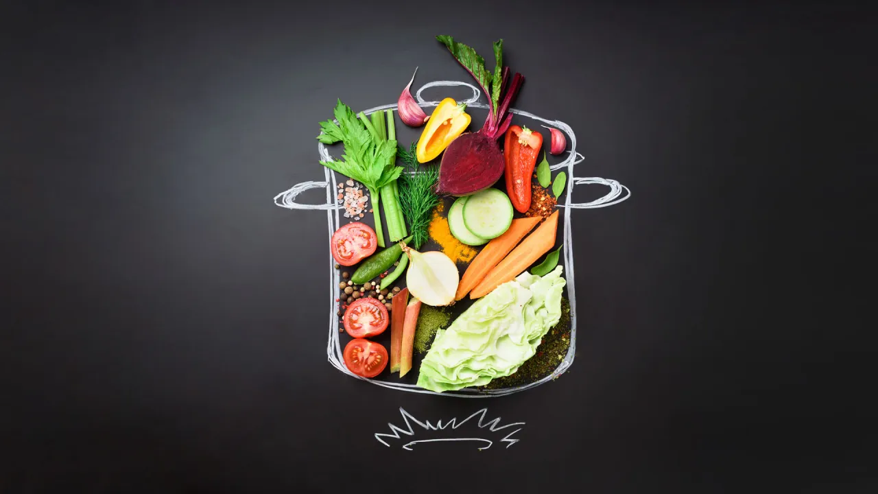 Kolorowe warzywa w garnku na czarnej tablicy, inspiracja jak gotowac zdrowo i dietetycznie.