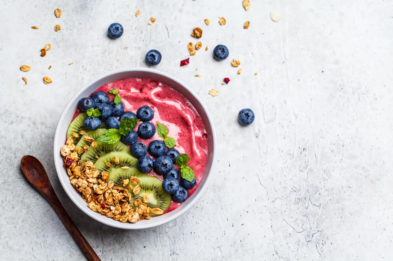 Kolorowa bowl z owocami jagodowymi, kiwi i granolą. Idealne zdrowe przepisy na śniadanie.