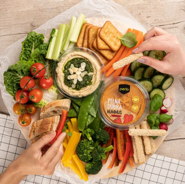 talerz hummusu z warzywami i pieczywem