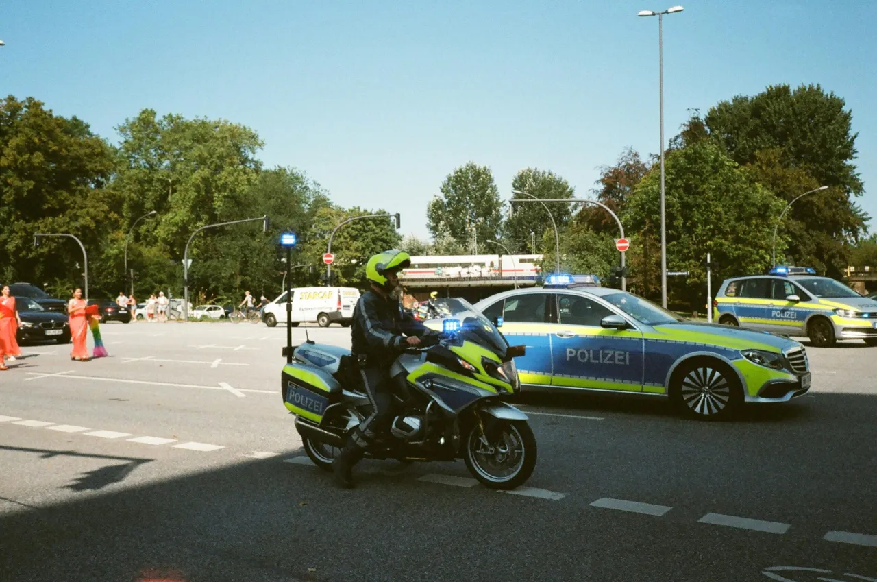 Niemiecka policja na motocyklu i w radiowozie. Niezapłacenie mandatu w Niemczech może prowadzić do poważnych konsekwencji.