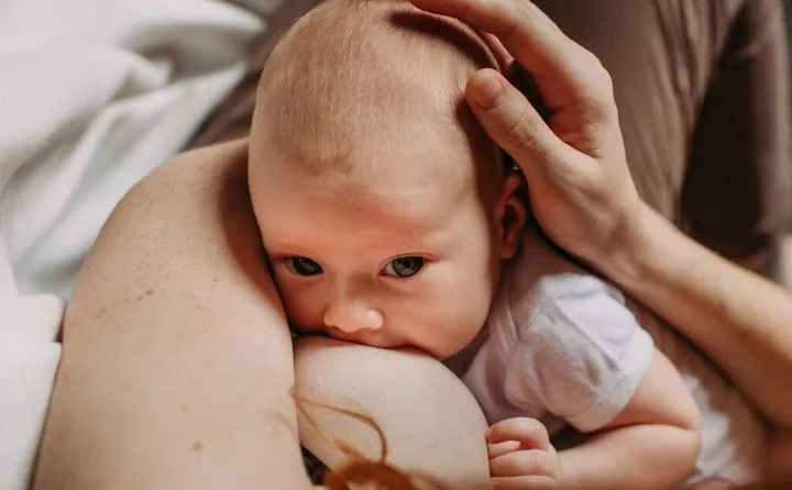szczęśliwe najedzone niemowlę po karmieniu piersią