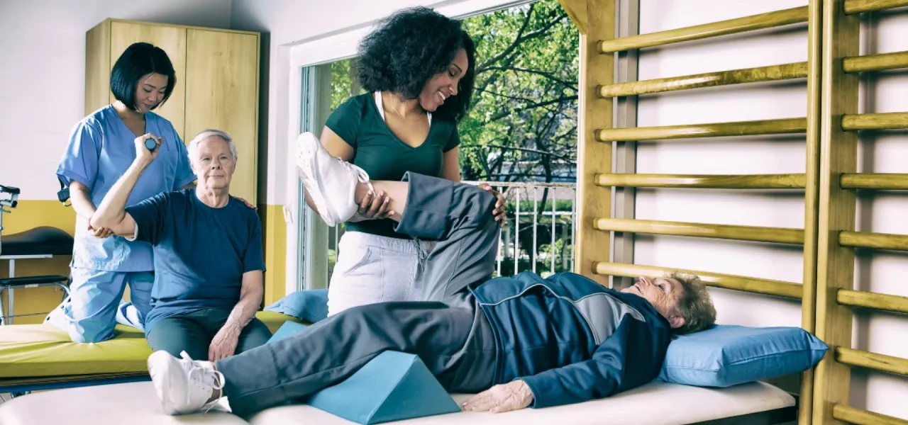 Rehabilitacja w sanatorium: fizjoterapeuci pomagają seniorom w ćwiczeniach. Jak załatwiać pobyt, by wr&oacute;cić do zdrowia.