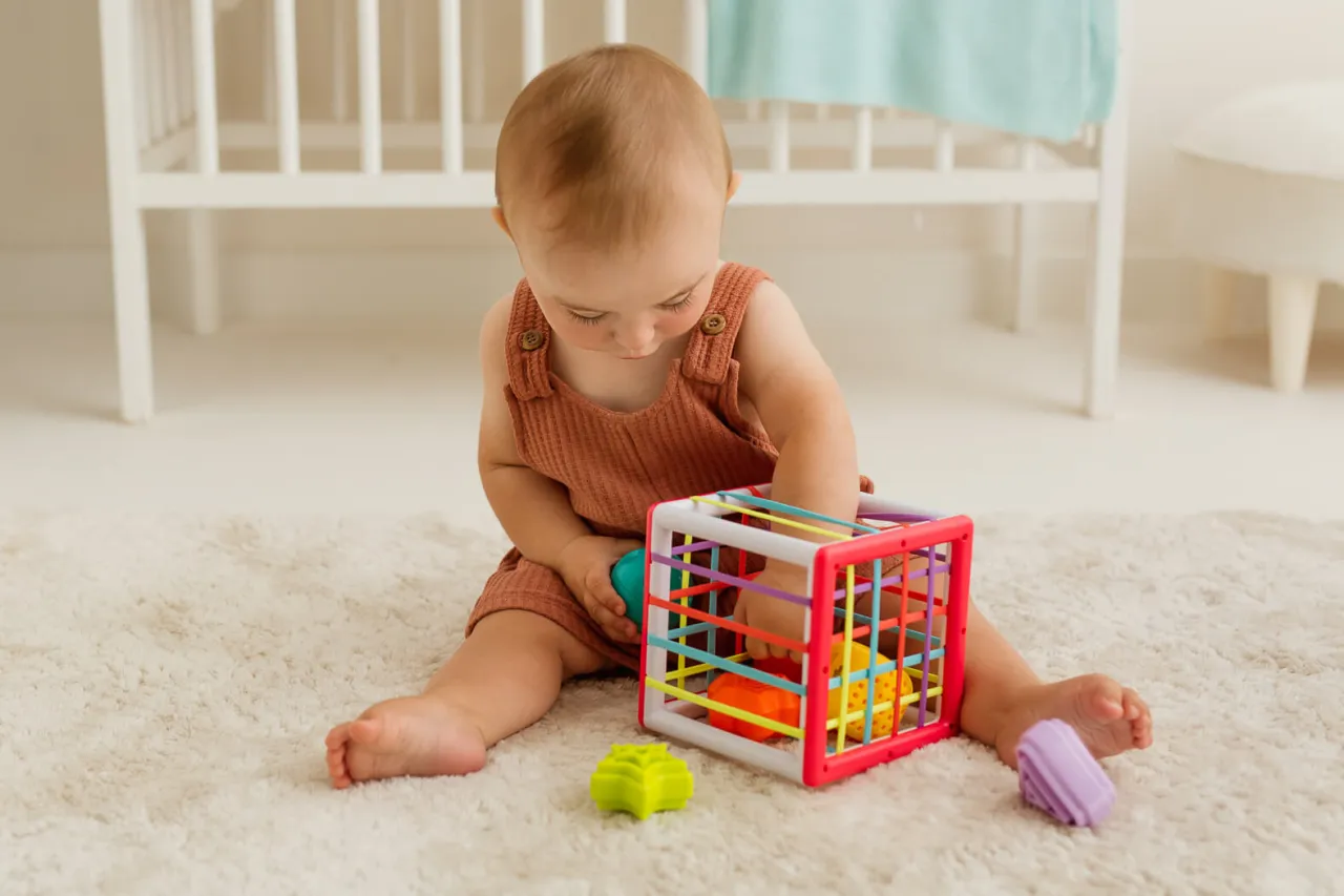 roczne dziecko bawi się sorterem kształtów