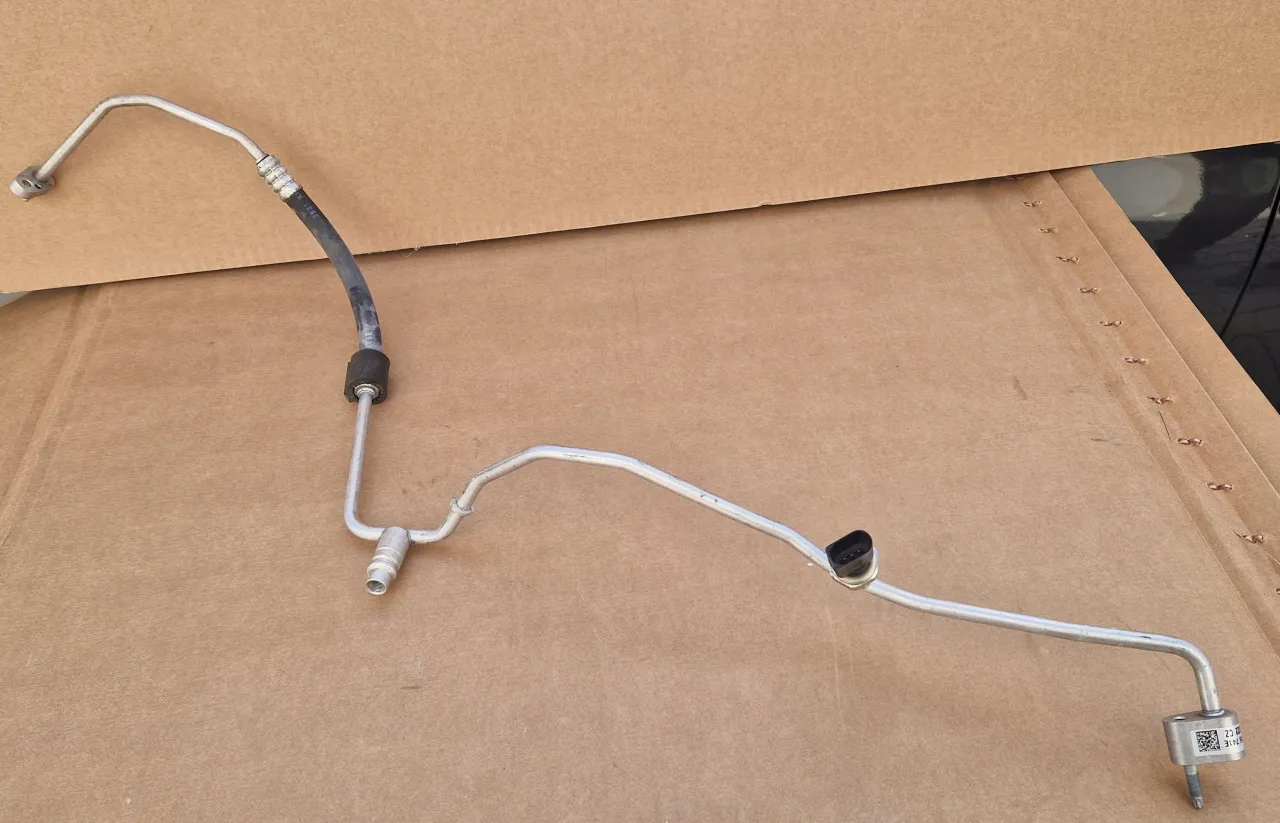 Przewód klimatyzacji samochodowej, metalowy z gumową osłoną i złączkami. Idealny, gdy zastanawiasz się, jaki kabel do klimatyzacji będzie najlepszy.