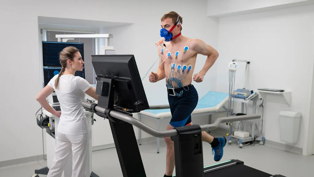 Osoba biegnąca na bieżni z widocznym pomiarem tętna