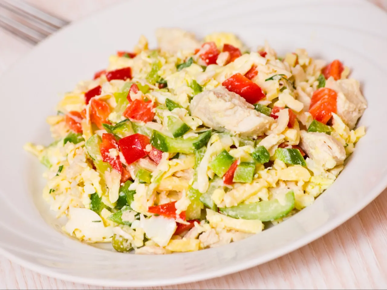 Kolorowa sałatka z kurczakiem, jajkiem, papryką i og&oacute;rkiem. Świetny pomysł na to, co można ugotować na szybki obiad.