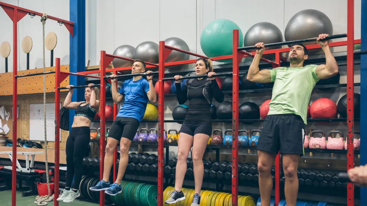 różnorodna grupa ludzi trenujących crossfit w boxie
