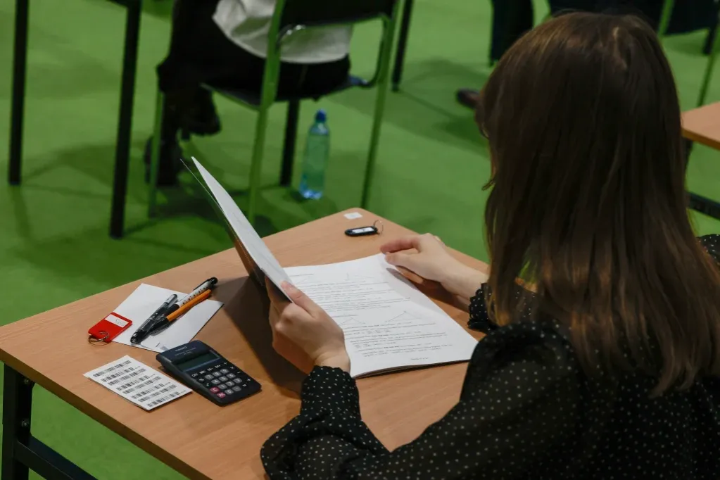 nauczyciel matematyki piszący dokumenty przy biurku w szkole