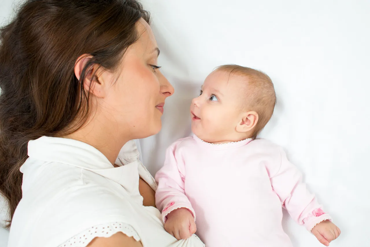 niemowlę patrzy na swoje rączki