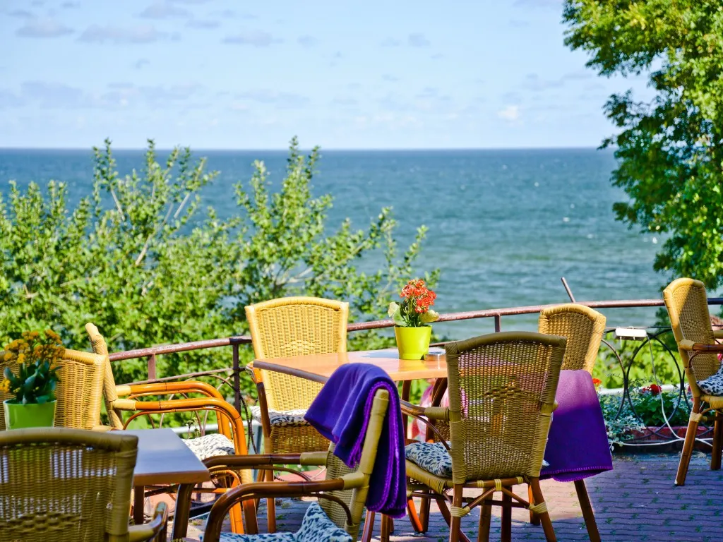 Restauracja z tarasem i widokiem na morze o zachodzie słońca Rewal